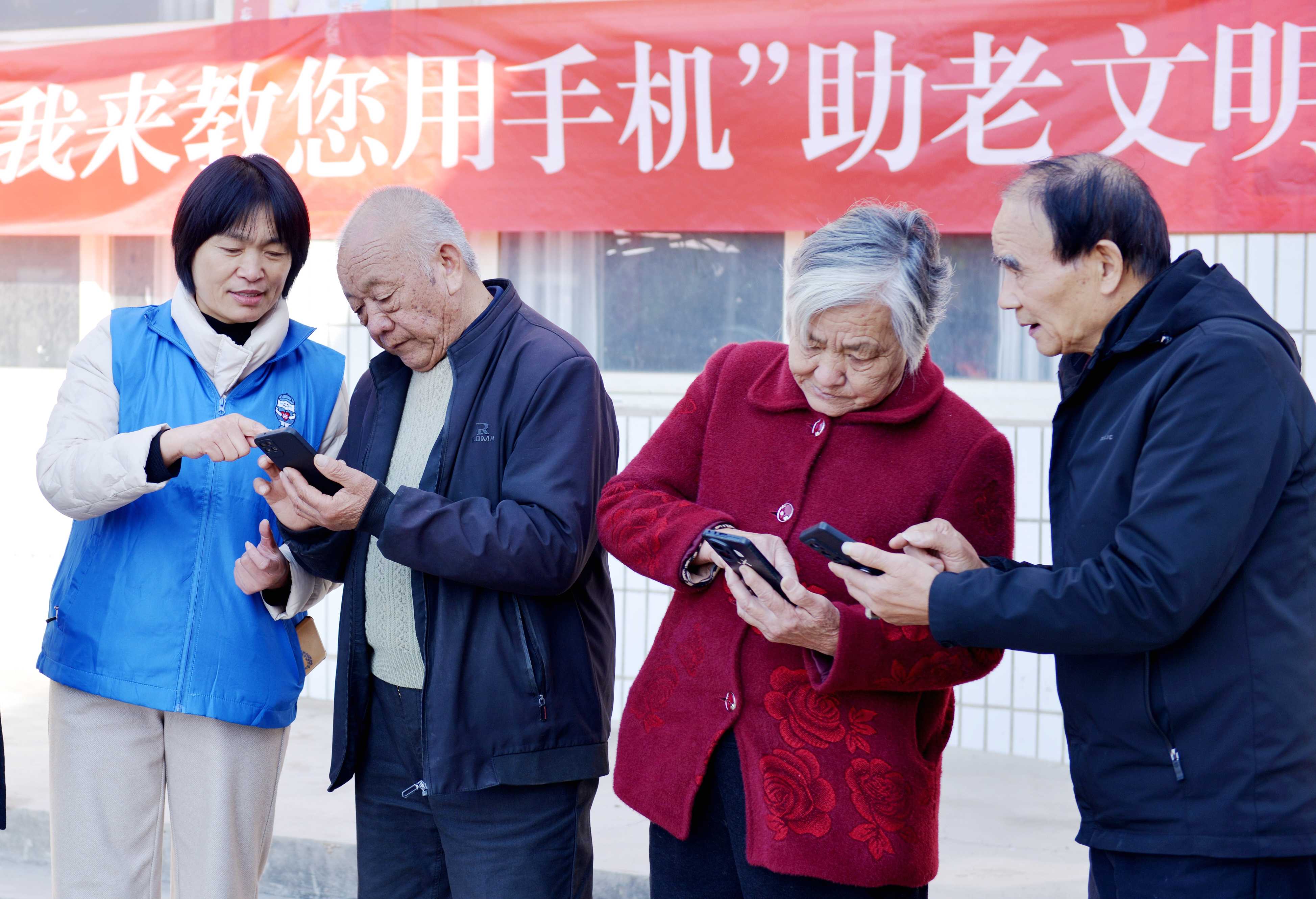 1月14日，禹州市关工委、禹州市精神文明建设促进中心联合在该市浅井镇张村庙村开展“我来教您用手机”助老文明实践活动，志愿者“手把手”教老年人使用智能手机，介绍社保认证、防范电信网络诈骗等实用技能。  本报记者   吕科 摄.jpg